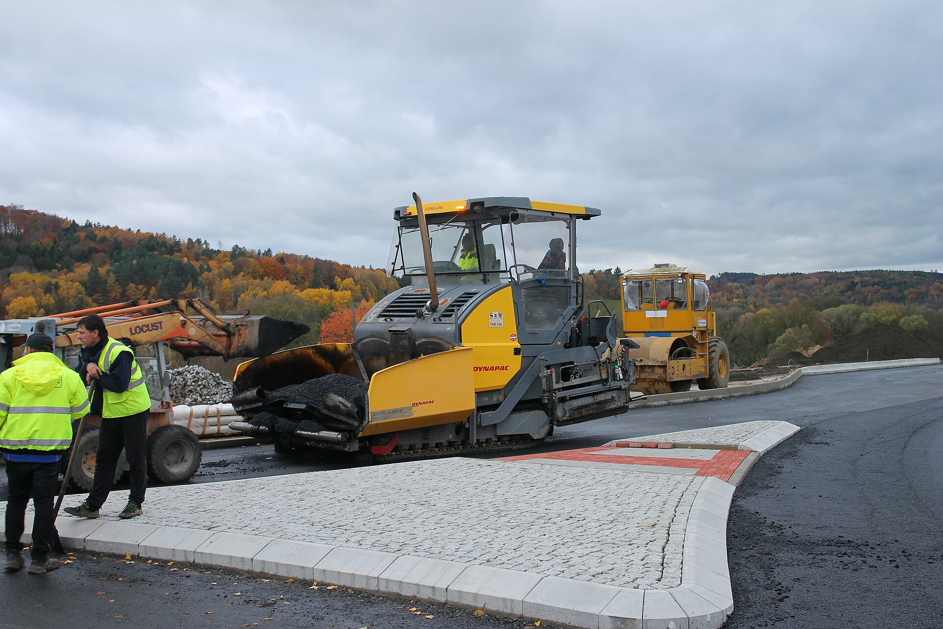 Silničáři s finišerem při pokládce asfaltu na obchvatu u Ktové